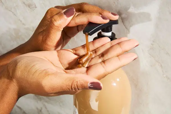 A person pumping the Luseta Beauty Jamaican Black Castor Oil Shampoo into their hand