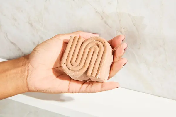 A person holding the Kitsch Rice Water Shampoo Bar for Hair Growth