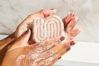 A person lathering the Kitsch Rice Water Shampoo Bar for Hair Growth in their hands