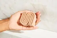 A person holding the Kitsch Rice Water Shampoo Bar for Hair Growth