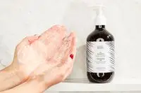 A person lathering the BondiBoost HG Shampoo for Thinning Hair in their hands