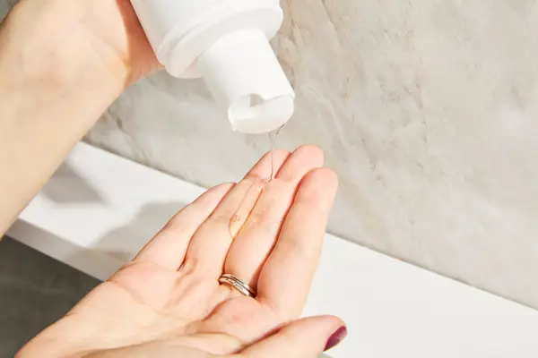 a person pouring Briogeo Destined For Density Caffeine + Biotin Density Shampoo into their hands