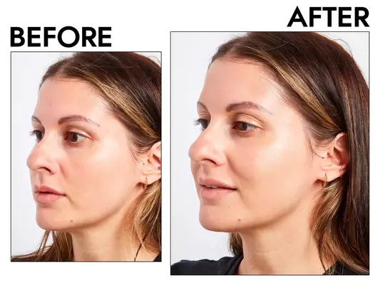 Hand holding a bottle of Flower Beauty Get Real Serum Foundation with foundation on the back of their hand