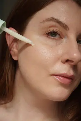 MYM Beauty writer Ashley Rebecca applies Deinde serum to skin using dropper