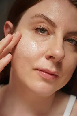 MYM Beauty writer Ashley Rebecca applying white cleanser to cheek with fingers