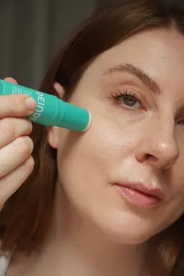 MYM Beauty writer Ashley Rebecca applying the Deinde moisture stick to her cheek