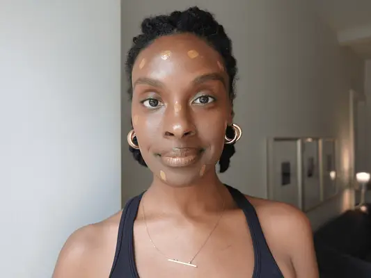 Essence Gant with dots of Kosas foundation on her face