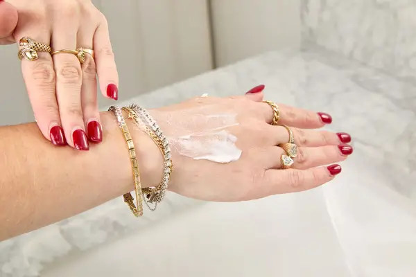 A person applying Vacation Classic Sunscreen Lotion to the back of their hand